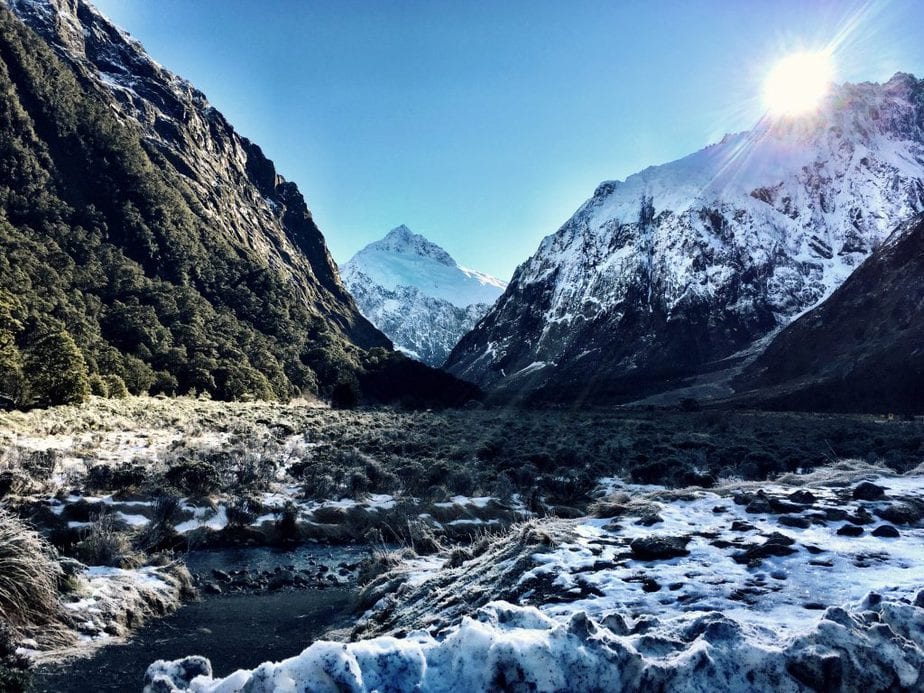 Snow covered mountains and ground during a bright sunny day in Fiordland National Park, NZ