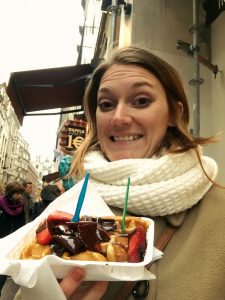 Me holding a famous belgian waffle topped with strawberries and chocolate