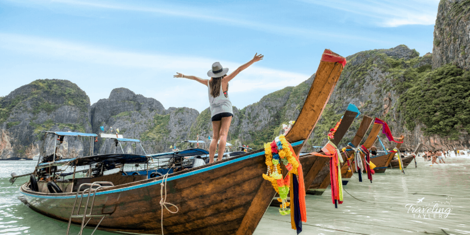 Girl standing on top of boats in Thailand on the beach